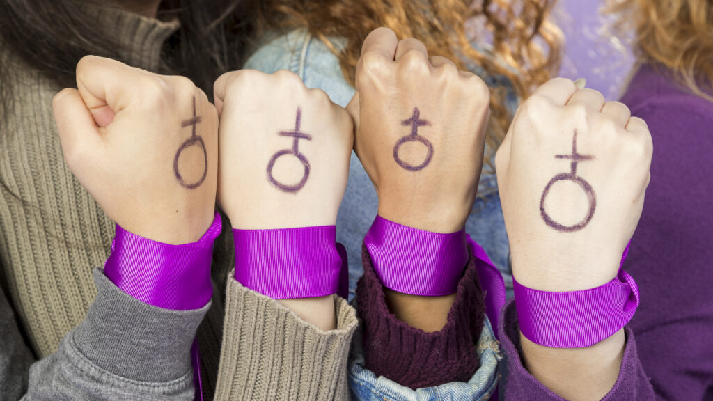 Foto Fäuste von Frauen mit Frauenzeichen in Lila